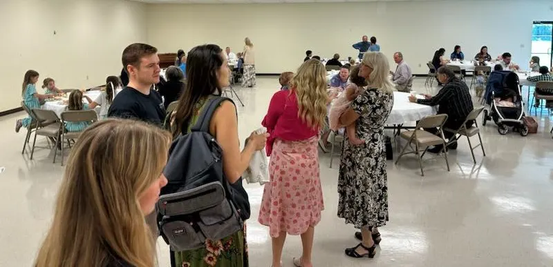 Church families talking together at a fellowship meal